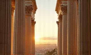 Contrast between Ancient Roman ruins and Modern glass skyscraper
